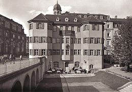 Černobílá fotografie zachycující barokní dům s věžičkou
